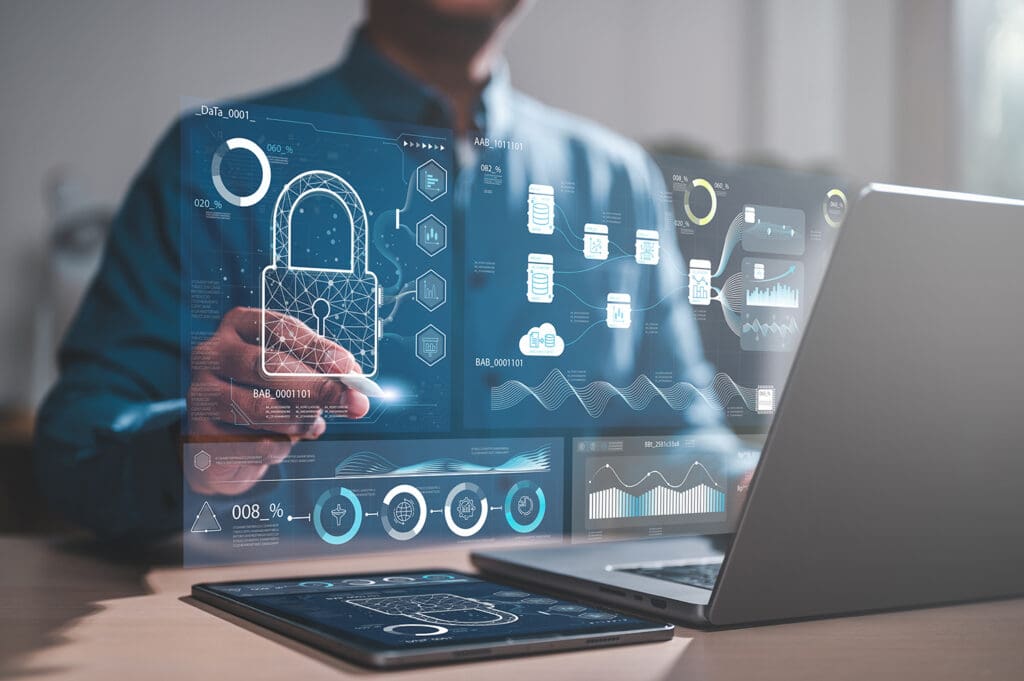 Person using a stylus with cybersecurity data and a digital lock icon on a transparent virtual screen near a laptop.